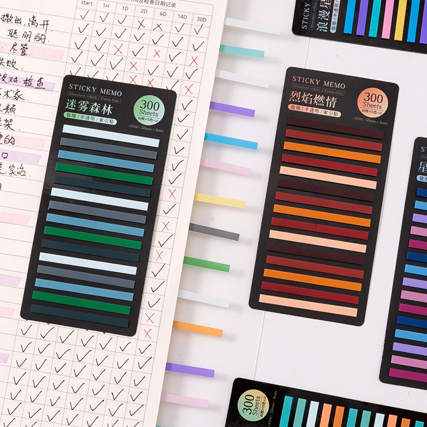 various sets of sticky index tabs in gradient colors, arranged beside an open notebook Some tabs are inserted into the notebook's pages
