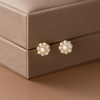 Pearl and Cubic Zirconia Stud Earrings Hanging on a Brown Jewelry Box