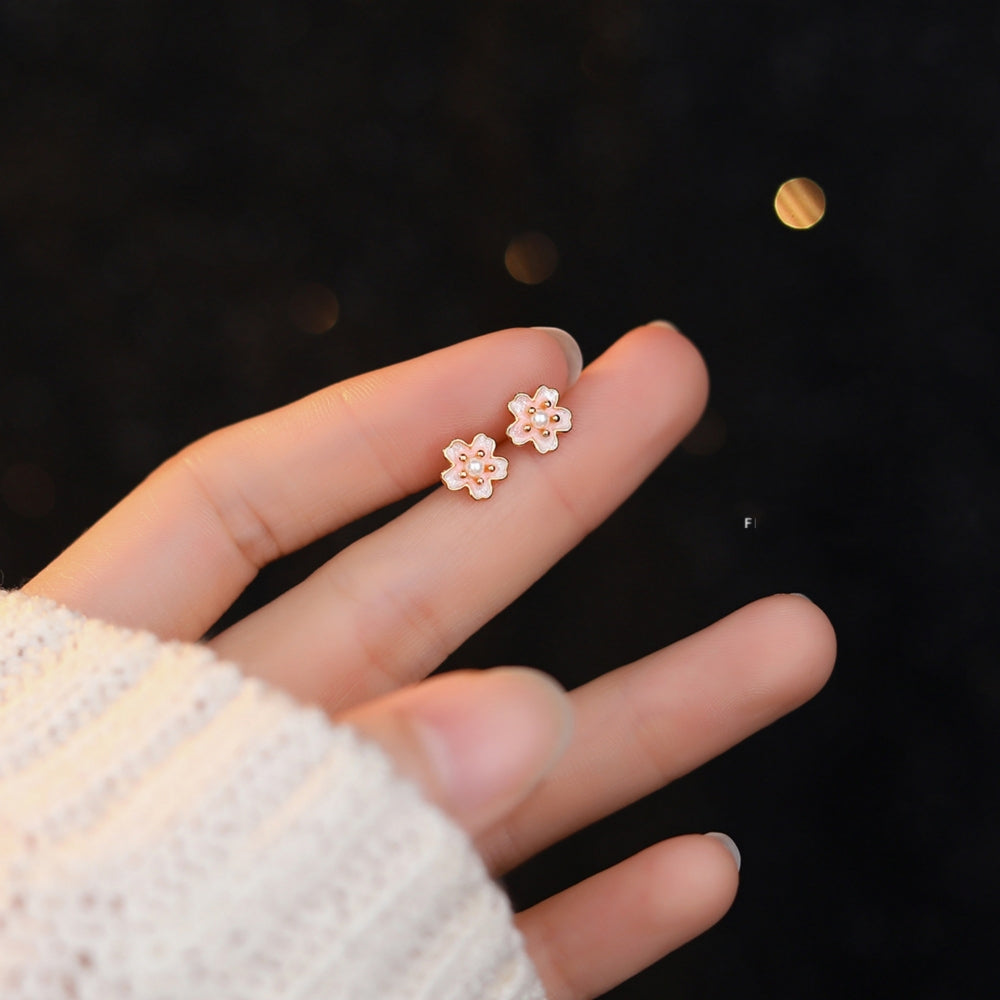 A Hand Holding A Pair of Sakura Floral Stud Earrings